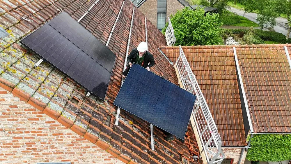 Monteur plaatst zonnepanelen op een dak